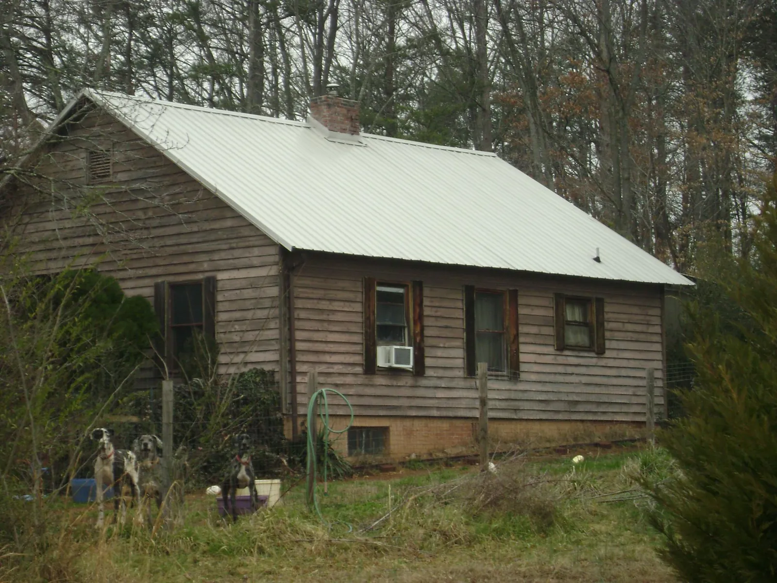 White metal roof on an old wood sided farmhouse, from a Metal Roof Installation job in Mabank